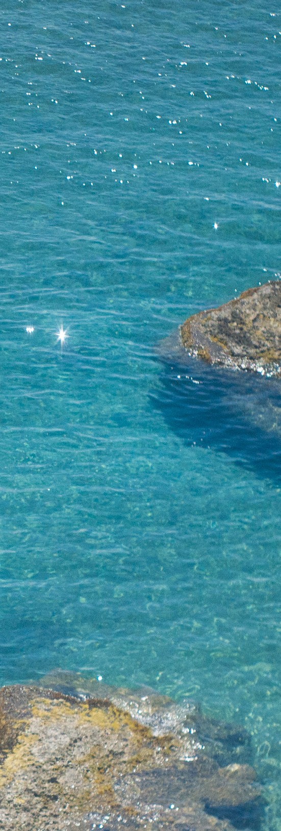 Clear turquoise Ionian sea over sunlit rocks